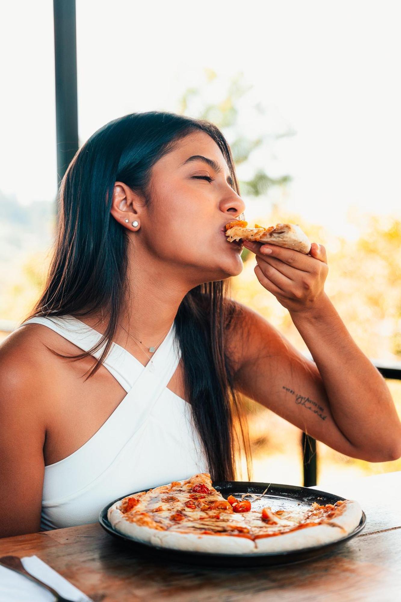 The Boato Hotel Guatapé Eksteriør bilde A woman eating pizza